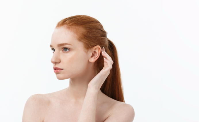 Model image of women with red hair touching her ear